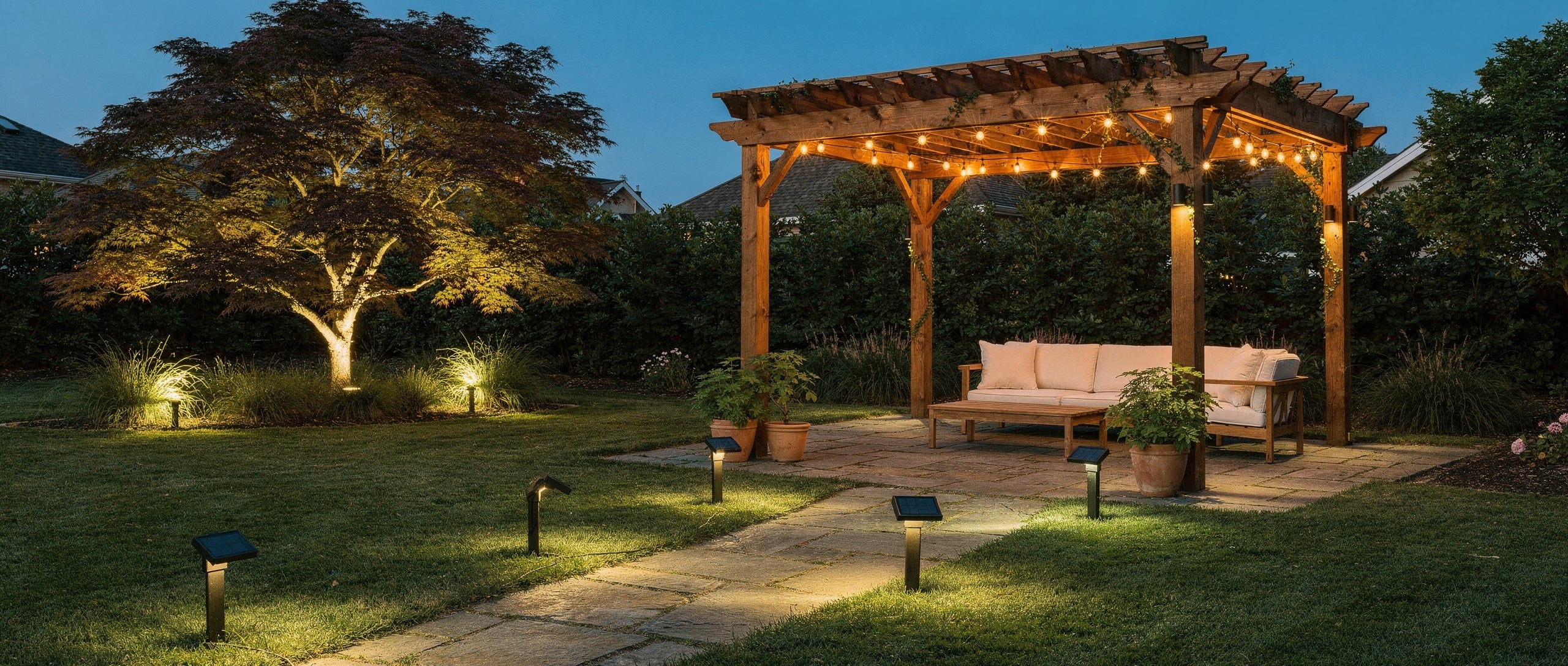 Solar string lights on a cedar pergola with solar path lights lining a flagstone walkway at dusk